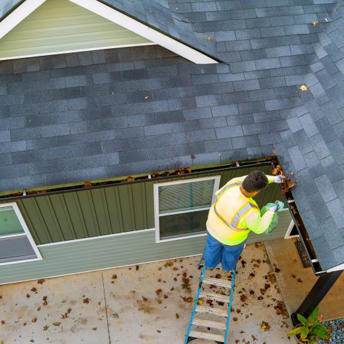 A Worker Is Cleaning Clogs In Roof Gutter Drain By Picking Up Dirt, Debris, Fallen Leaves