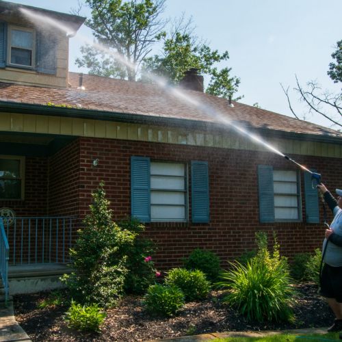 experienced roof cleaners pressure washing the roof