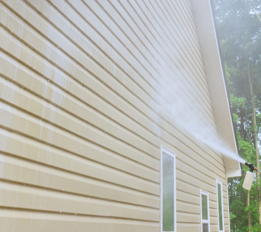 Service Worker Utilizes High Pressure Nozzles To Efficiently Clean Siding Houses With A Water Soap Cleaner.